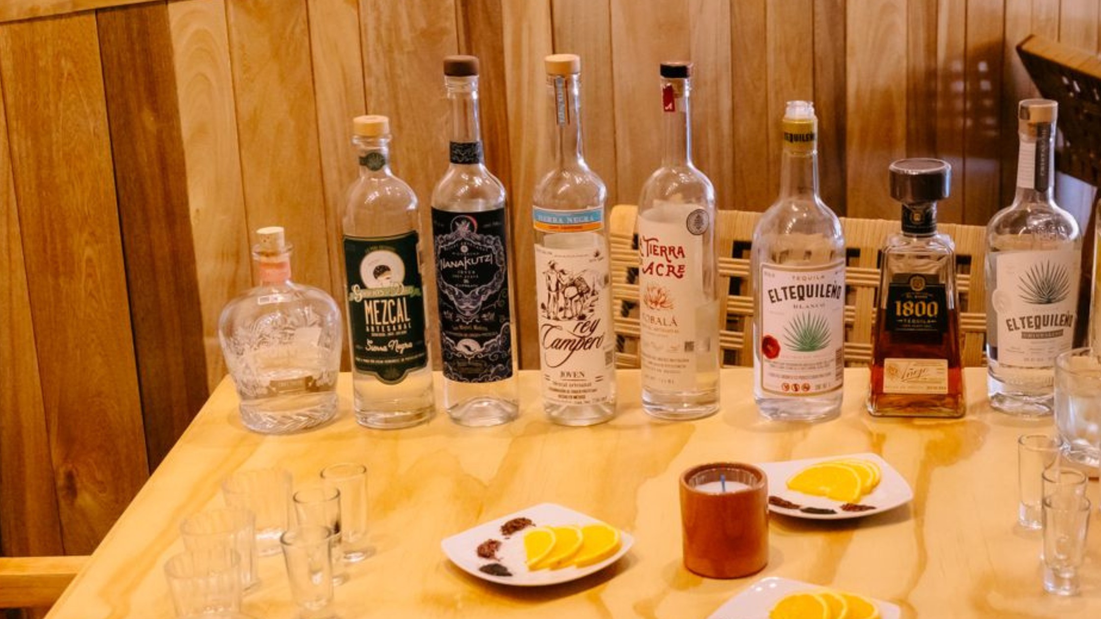 Professional tequila tasting setup with various glasses and premium bottles